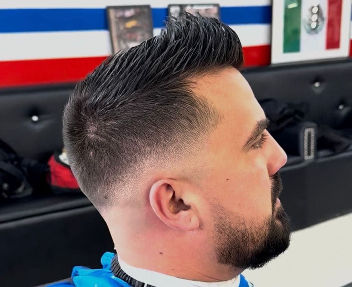 Slicked pompadour with a mid fade
