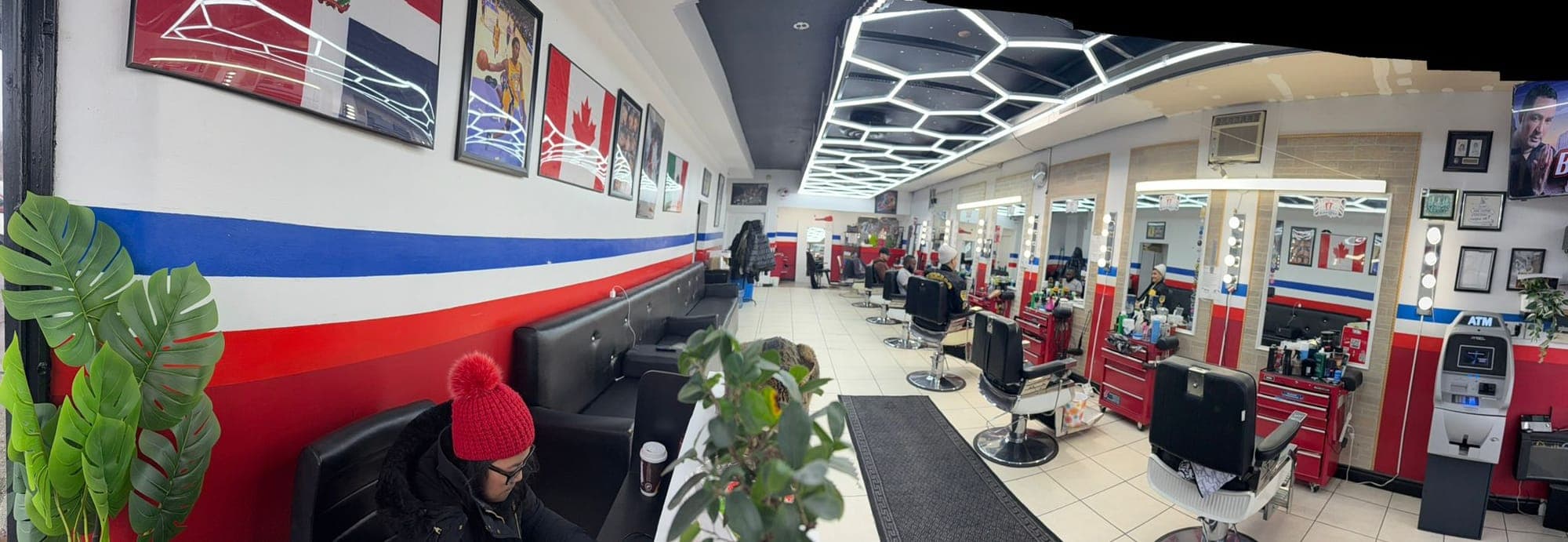 Inside the Keele Street shop — a long row of chairs under honeycomb lights and the red, white and blue wall